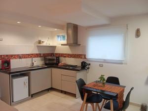 a small kitchen with a table and a table and chairs at Prunus departamentos in Comodoro Rivadavia