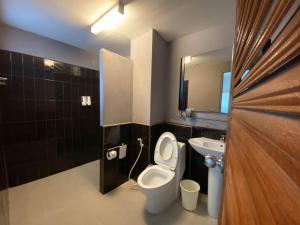 a bathroom with a toilet and a sink and a mirror at Sino @ Thungsong in Thung Song +62 photos