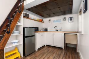 a kitchen with white cabinets and a black refrigerator at Cozy Tiny Home on an Eco Farm Huge Yard in Austin