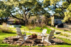 two white chairs sitting in a fire pit in a yard at Cozy Tiny Home on an Eco Farm Huge Yard in Austin +7 photos