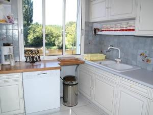 una cucina con mobili bianchi, un lavandino e una finestra di Charmante maison XIXe siècle bord de Vézère - FR-1-824-6 a Le Bugue Altre 14 foto