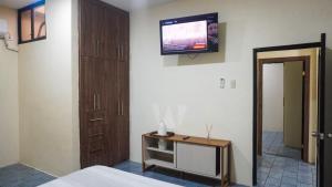 a bedroom with a tv on the wall and a bed at Departamento completo, facso in Cuatro Hermanas