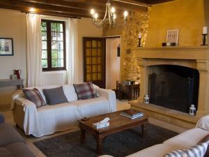 a living room with a couch and a fireplace at Charmante maison en pierre avec piscine privée, 8 personnes, proche des Bastides - FR-1-824-19 in Le Buisson de Cadouin