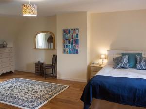 a bedroom with a bed and a chair and a mirror at Charmante maison en pierre avec piscine privée, 8 personnes, proche des Bastides - FR-1-824-19 in Le Buisson de Cadouin +17 photos