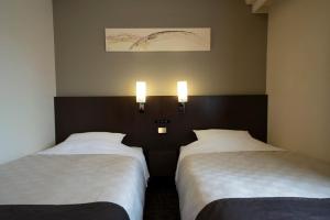 Rúm í herbergi á Hotel Binario Umeda