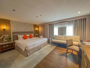 una camera d'albergo con un letto e un divano di Hotel St. Ellis a Legazpi