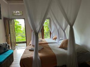 a bedroom with a bed with a canopy at Omunity Bali in Singaraja