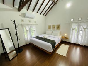 a white bedroom with a large bed with white curtains at Spacious 3BR Villa Near Kaliurang - Arfani's House in Ngaglik