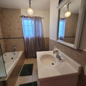a bathroom with a sink and a bath tub at 3 bedroom 2 bath home with Jacuzzi near Beverly Hills, wi-fi, Jacuzzi, Roku, BBQ, giant games family fun in Los Angeles +16 photos