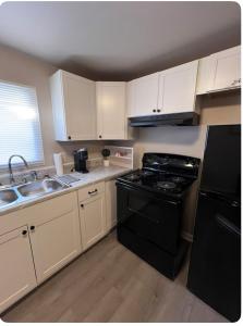 a kitchen with a black stove and a sink at Skipper Apt 1 in Rockingham