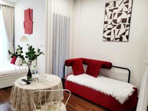 Una habitación con una cama con almohadas rojas y una mesa. en Max Housing, en Phú Thú 13 fotos más