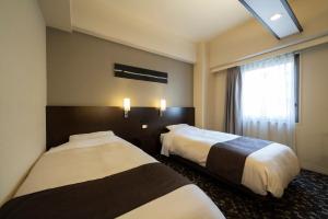 Rúm í herbergi á Hotel Binario Umeda