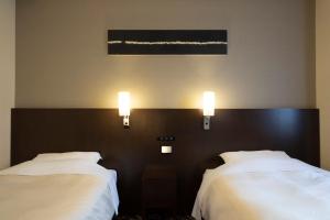 Rúm í herbergi á Hotel Binario Umeda