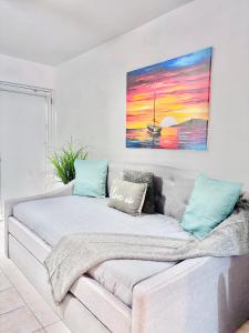 a couch in a living room with a painting on the wall at Stay practico y moderno en Carolina cerca de la zona turística de Isla Verde in Carolina