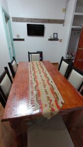 a wooden table in a room with chairs and a television at Mi LUGAR EN MALARGÜE in Malargüe