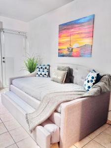 a couch in a living room with a painting on the wall at Stay practico y moderno en Carolina cerca de la zona turística de Isla Verde in Carolina