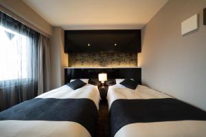 Rúm í herbergi á Hotel Binario Umeda