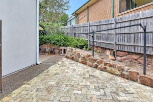 a brick walkway next to a building with a fence at Coastal Bliss Studio at Shoal Bay in Shoal Bay