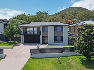 a house with a mountain in the background at Coastal Bliss Studio at Shoal Bay in Shoal Bay