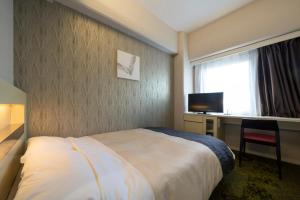 Rúm í herbergi á Hotel Binario Umeda