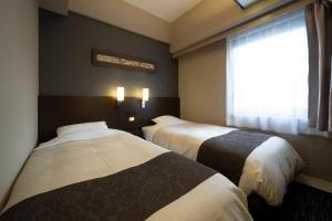 Rúm í herbergi á Hotel Binario Umeda