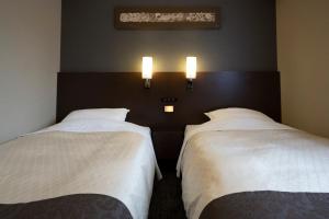 Rúm í herbergi á Hotel Binario Umeda