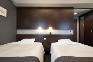 Rúm í herbergi á Hotel Binario Umeda