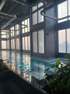 Una gran piscina en un edificio con ventanas. en Max Housing, en Phú Thú