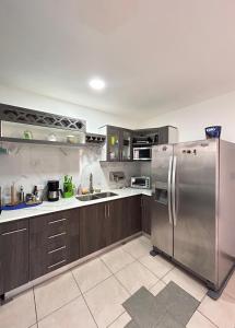 a large kitchen with a stainless steel refrigerator at Villa Lapas in Bejuco +6 photos