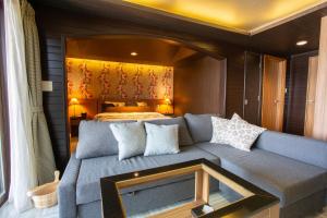 un soggiorno con un divano di fronte a un letto di LCO-Resort a Takizawa Altre 2 foto