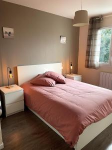 ein Schlafzimmer mit einem großen Bett mit einer roten Bettdecke in der Unterkunft La maison de CASTETS entre forêt et océan in Castets