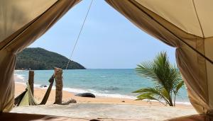 a view of the beach from the inside of a tent at KAMAKU Bungalows - Sunset Beach in Koh Rong Sanloem