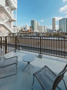 a patio with two chairs and a table on a balcony at illi Tex Aoyama in Tokyo