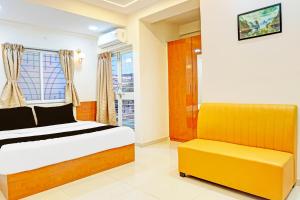 a bedroom with a bed and a yellow bench at Townhouse Surya Inn in Pune