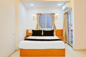 a bedroom with a bed and a window at Townhouse Surya Inn in Pune