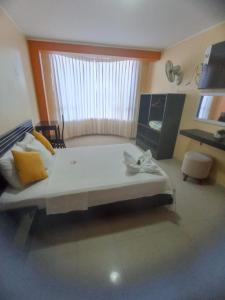 a large bed in a room with a window at Royal Plaza Hotel Suite in Nueva Cajamarca