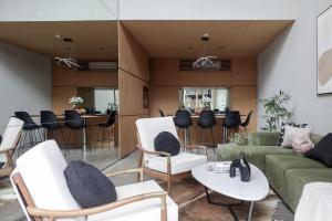 a living room with white furniture and a green couch at OXO Townhouses Berawa Canggu in Canggu