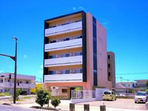a tall building with cars parked in front of it at COZYSTAY group ブラウンシュガー in Miyako Island