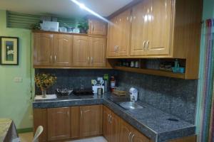 a kitchen with wooden cabinets and a sink at Sinoben Apartments by RedDoorz in Santa Barbara