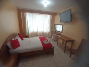 a bedroom with a bed and a desk and a television at Royal Plaza Hotel Suite in Nueva Cajamarca +7 photos