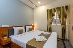 班加罗尔Hotel Chalet, Madiwala的一间带大床和窗户的卧室