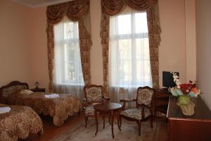 een kamer met 2 bedden en een tafel en stoelen bij Pałac w Nosowie in Nosowo