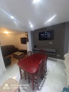 Lovely house for family & group في Wyken: طاولة طعام مع كراسي وتلفزيون على الحائط