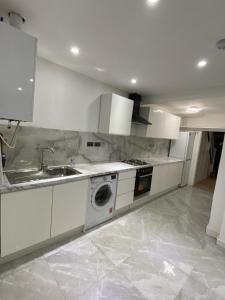 Lovely house for family & group في Wyken: مطبخ مع حوض وغسالة ملابس