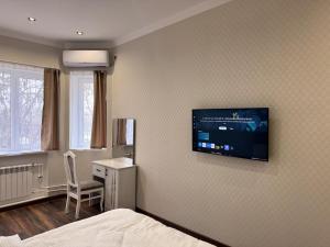 a bedroom with a bed and a tv on the wall at Magic City Apartments 2 in Tashkent