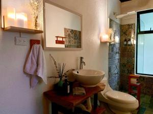 a bathroom with a sink and a toilet at Luna Escondida in Sarapiquí