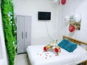 a room with a bed with a green wall and balloons at Blue Ocean Apartment in Noord