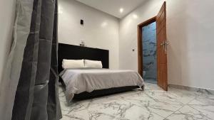 a bedroom with a bed in a room with marble floors at OREMA Residence in Cotonou