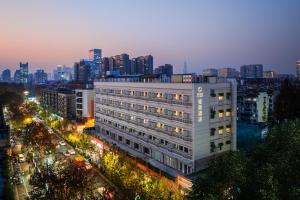 南京南京博物院瑞金路轻居酒店的夜晚城市中的一座白色大楼