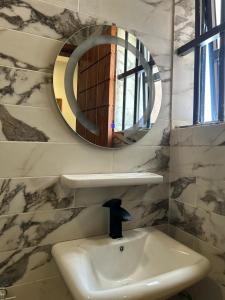 a bathroom with a sink and a mirror at OREMA Residence in Cotonou +3 photos
